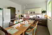 langer Tisch am Fenster mit Küchenzeile