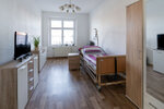 geräumiges Zimmer mit Pflegebett und Schränken