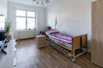 geräumiges Zimmer mit Pflegebett und Schränken