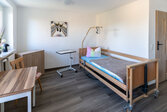 grosses helles Zimmer mit Pflegebett und Schränken